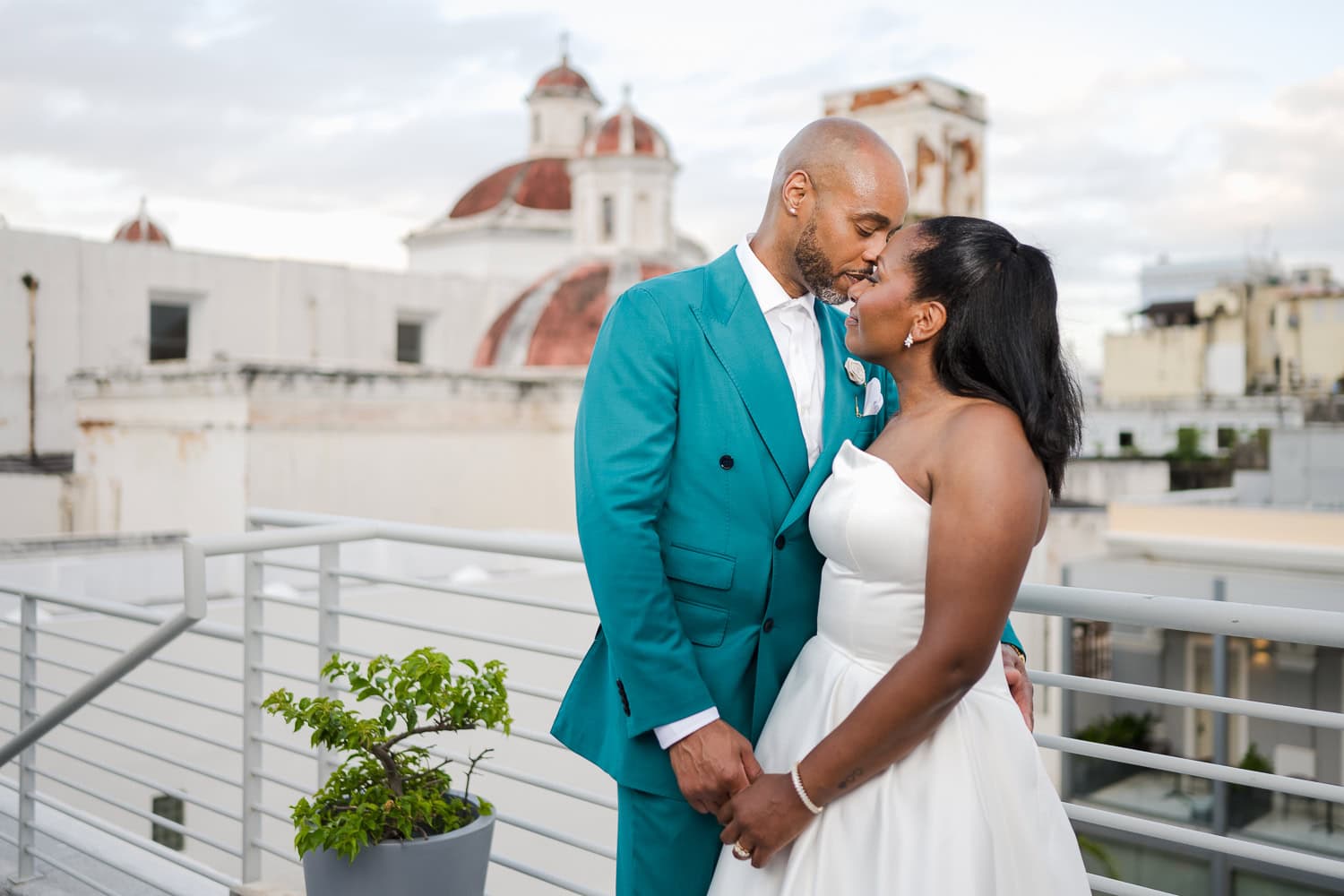 A newlywed couple sharing a tender moment on a rooftop with historic Old San Juan architecture in the background during their intimate destination wedding.