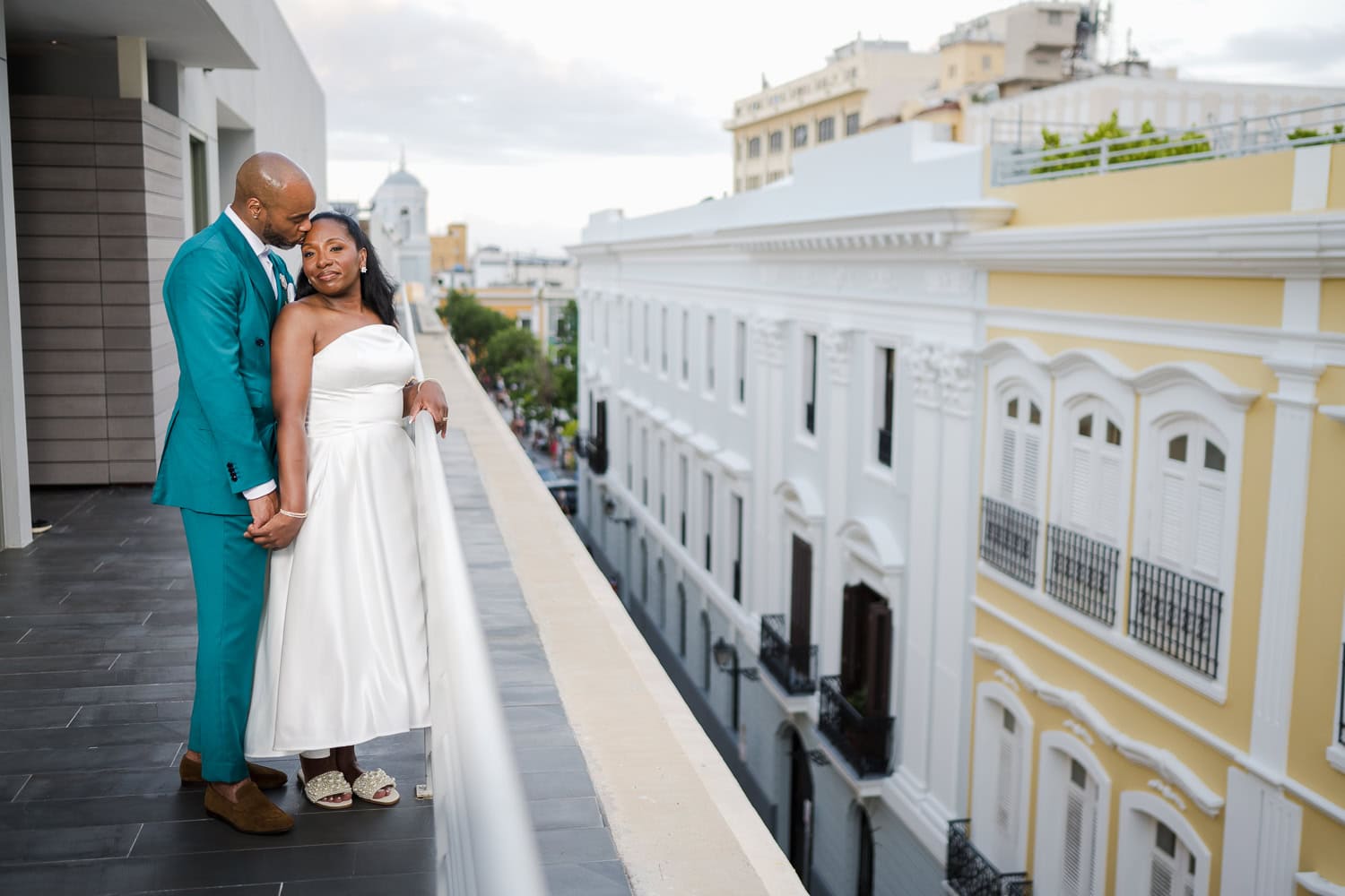 A newlywed couple sharing a tender moment on a rooftop with historic Old San Juan architecture in the background during their intimate destination wedding.