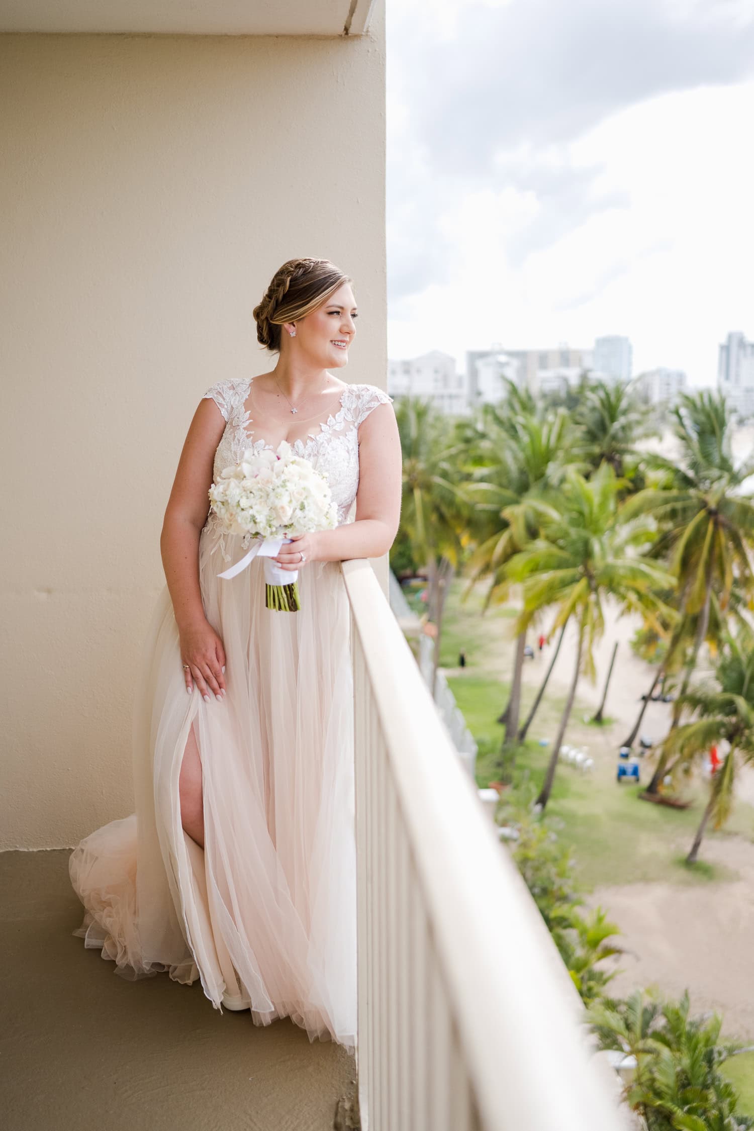 Beachfront wedding ceremony setup with a floral arch and palm trees at Courtyard Marriott Isla Verde, Puerto Rico.