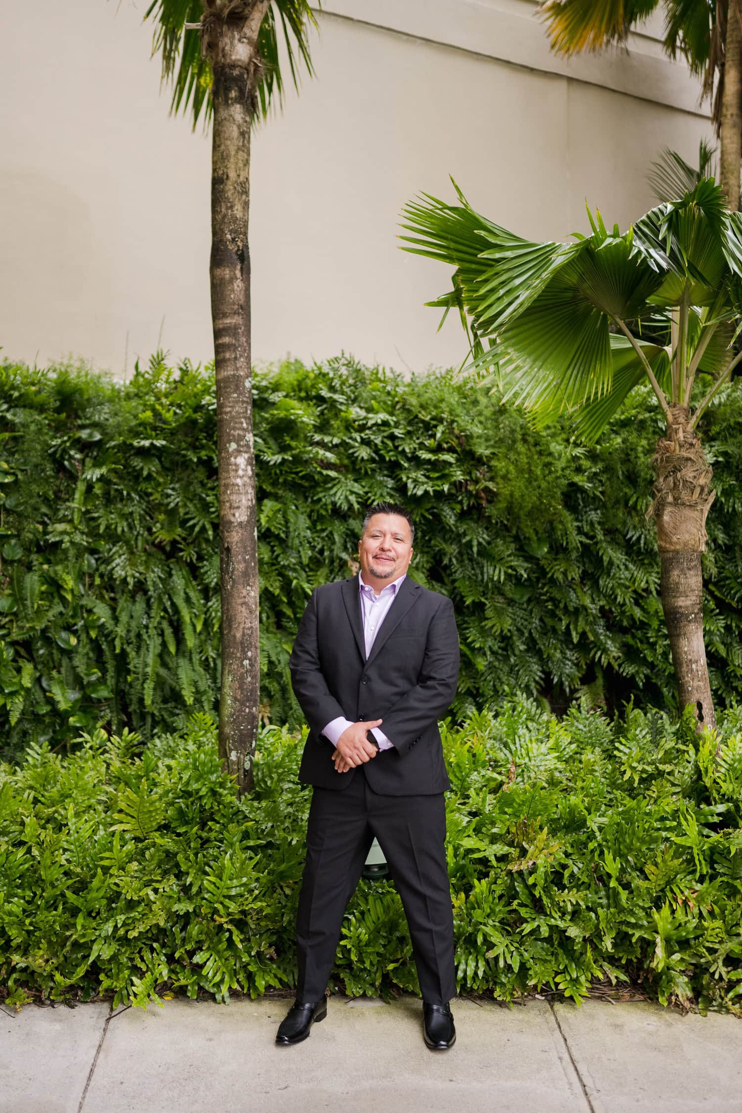 Beachfront wedding ceremony setup with a floral arch and palm trees at Courtyard Marriott Isla Verde, Puerto Rico.