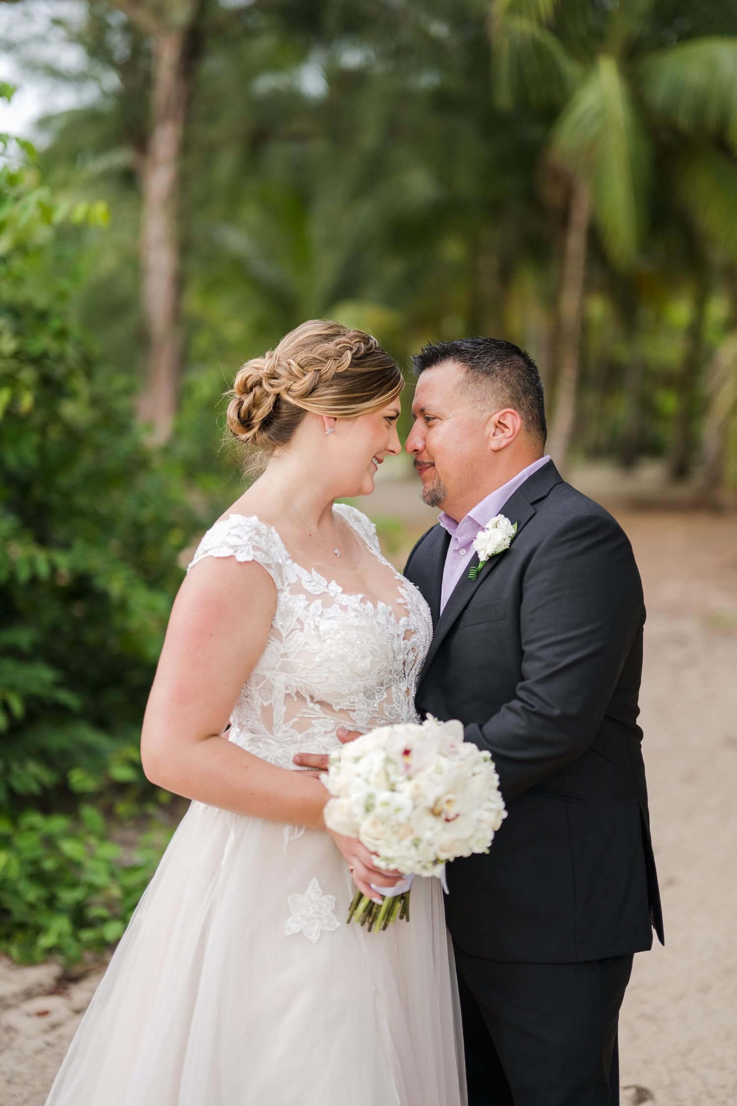 Beachfront wedding ceremony setup with a floral arch and palm trees at Courtyard Marriott Isla Verde, Puerto Rico.