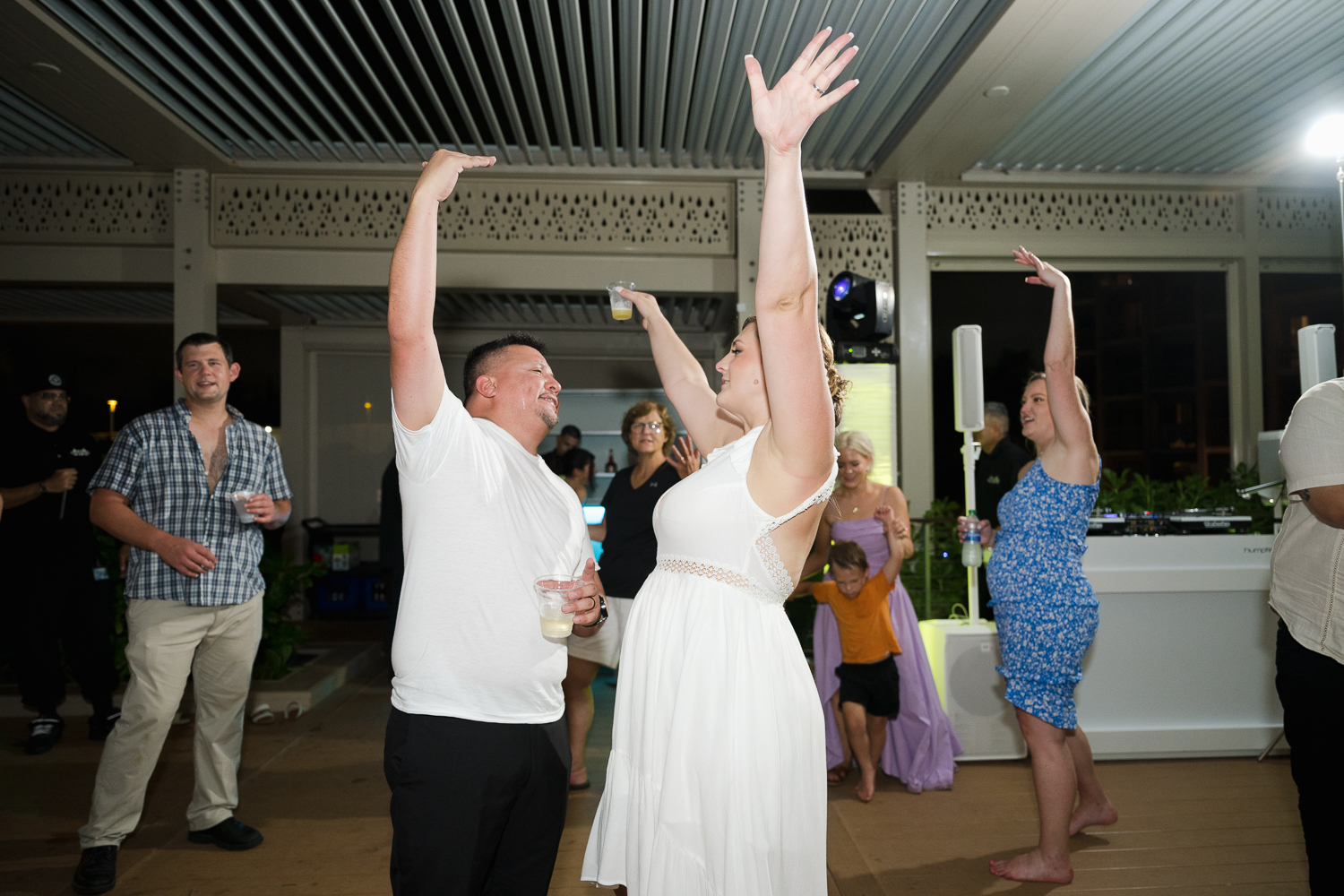 Beachfront wedding ceremony setup with a floral arch and palm trees at Courtyard Marriott Isla Verde, Puerto Rico.