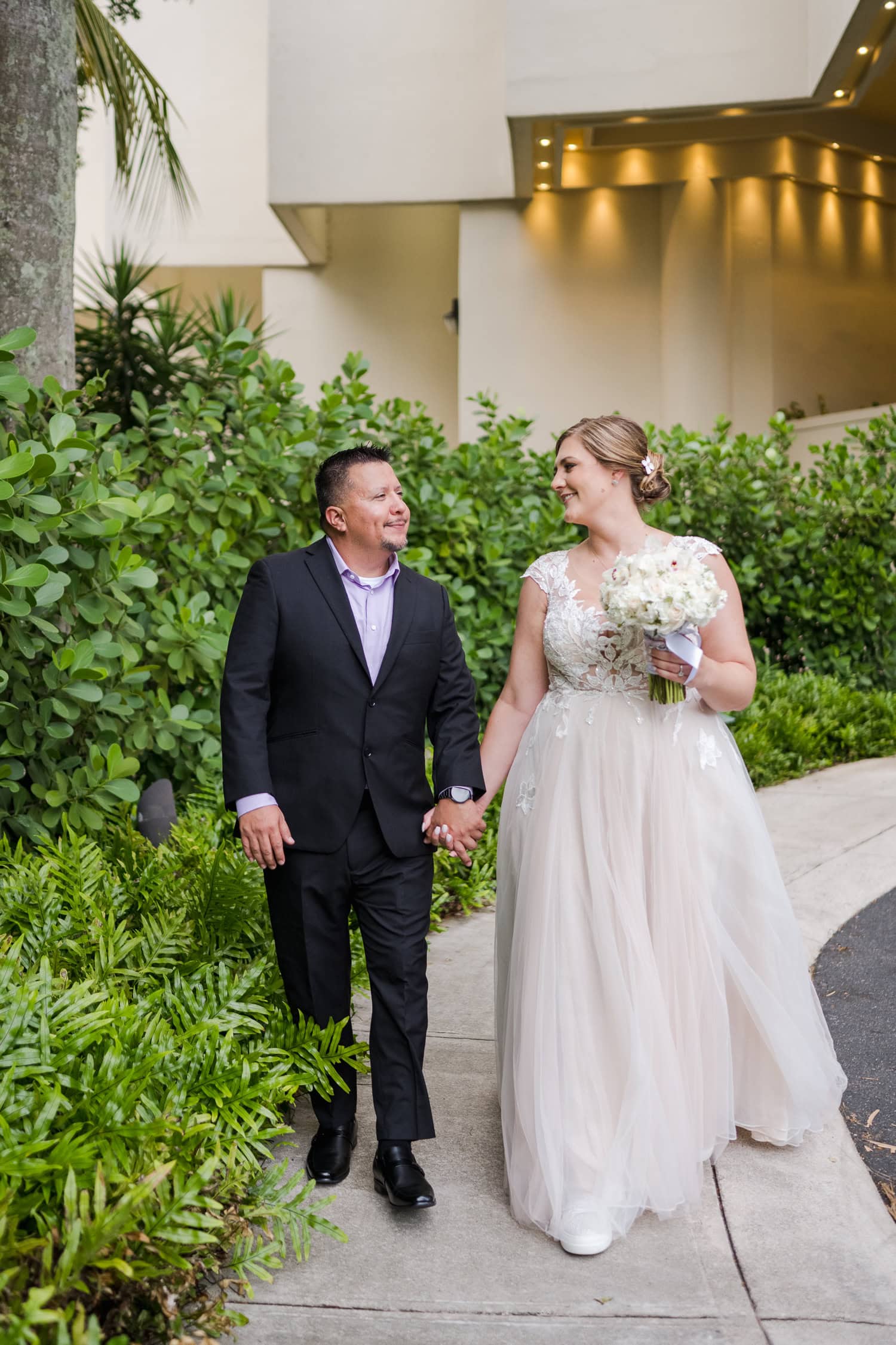 Beachfront wedding ceremony setup with a floral arch and palm trees at Courtyard Marriott Isla Verde, Puerto Rico.