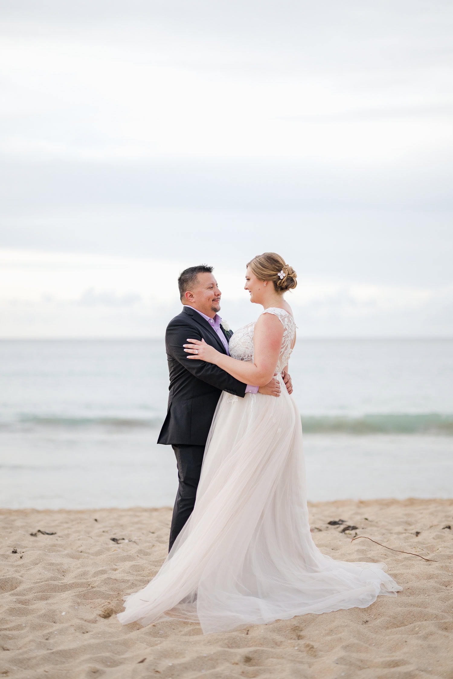 Beachfront wedding ceremony setup with a floral arch and palm trees at Courtyard Marriott Isla Verde, Puerto Rico.