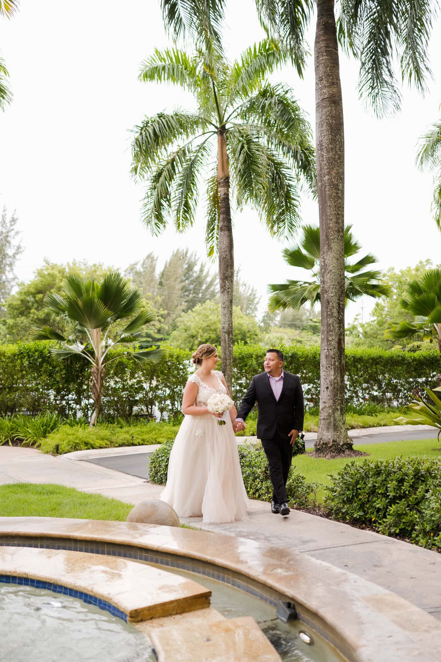 Beachfront wedding ceremony setup with a floral arch and palm trees at Courtyard Marriott Isla Verde, Puerto Rico.