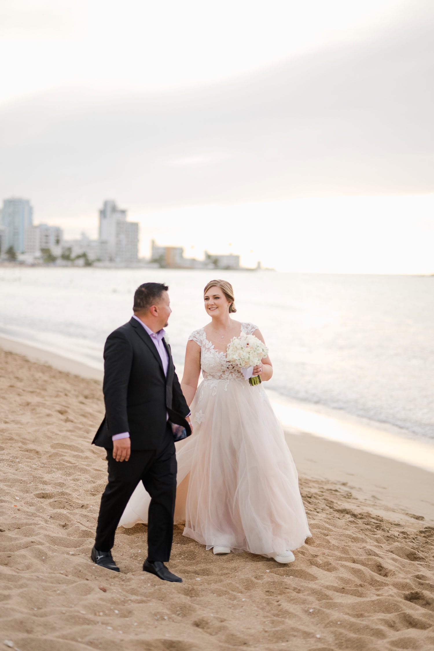 Beachfront wedding ceremony setup with a floral arch and palm trees at Courtyard Marriott Isla Verde, Puerto Rico.