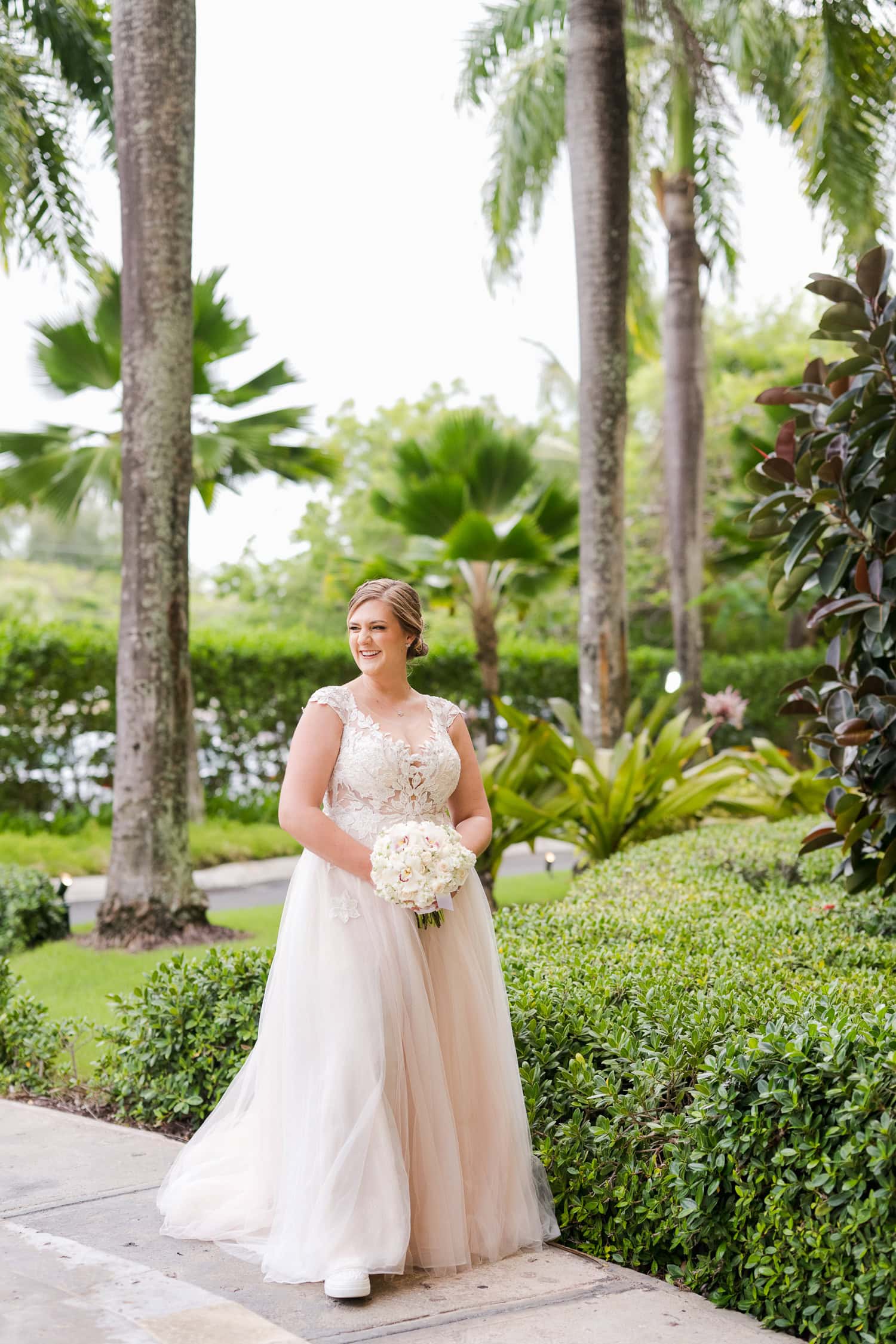 Beachfront wedding ceremony setup with a floral arch and palm trees at Courtyard Marriott Isla Verde, Puerto Rico.