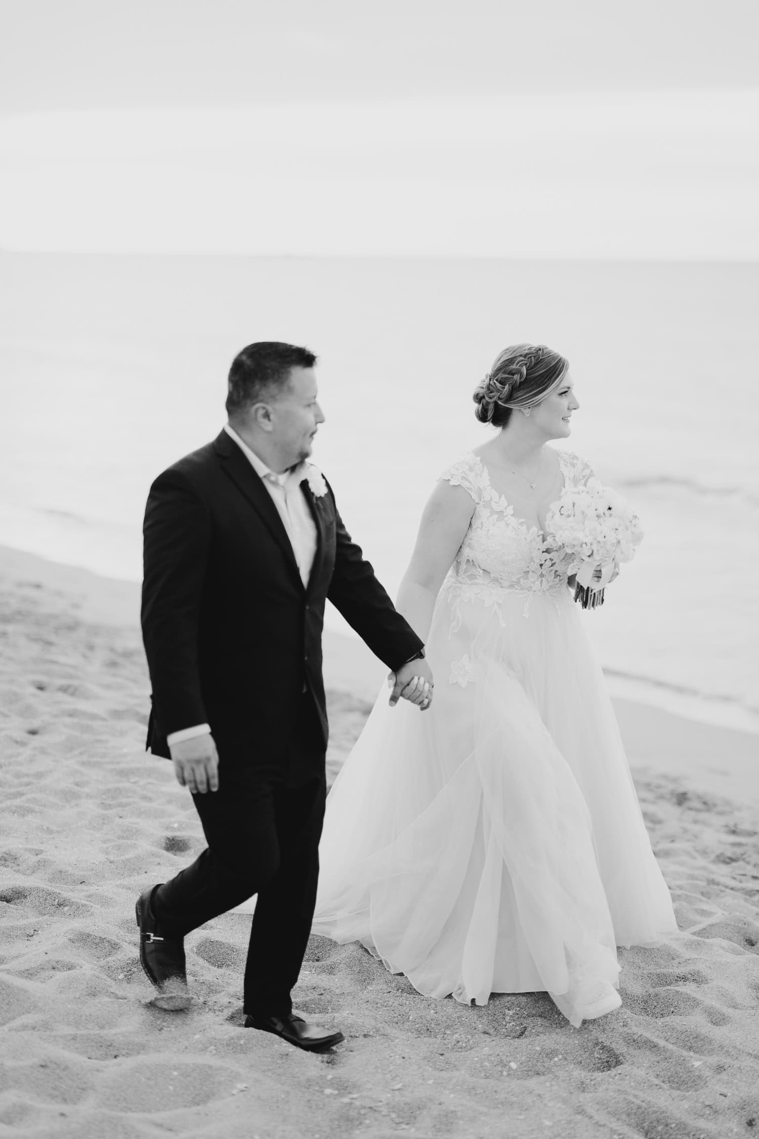 Beachfront wedding ceremony setup with a floral arch and palm trees at Courtyard Marriott Isla Verde, Puerto Rico.