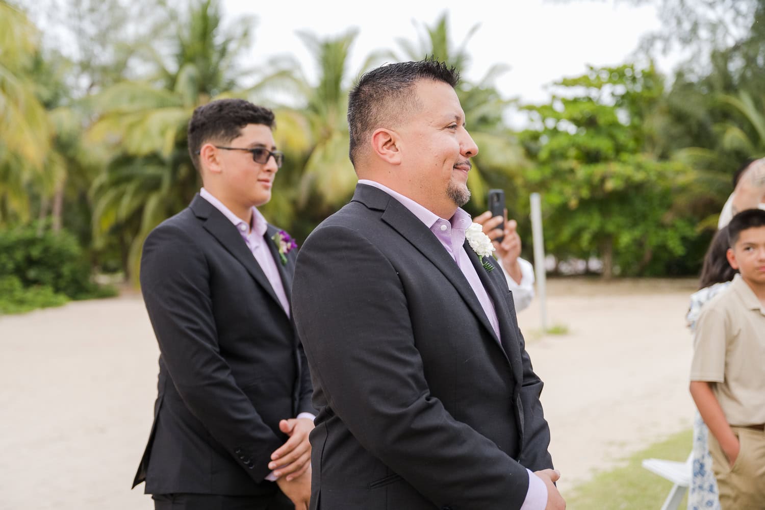 Beachfront wedding ceremony setup with a floral arch and palm trees at Courtyard Marriott Isla Verde, Puerto Rico.