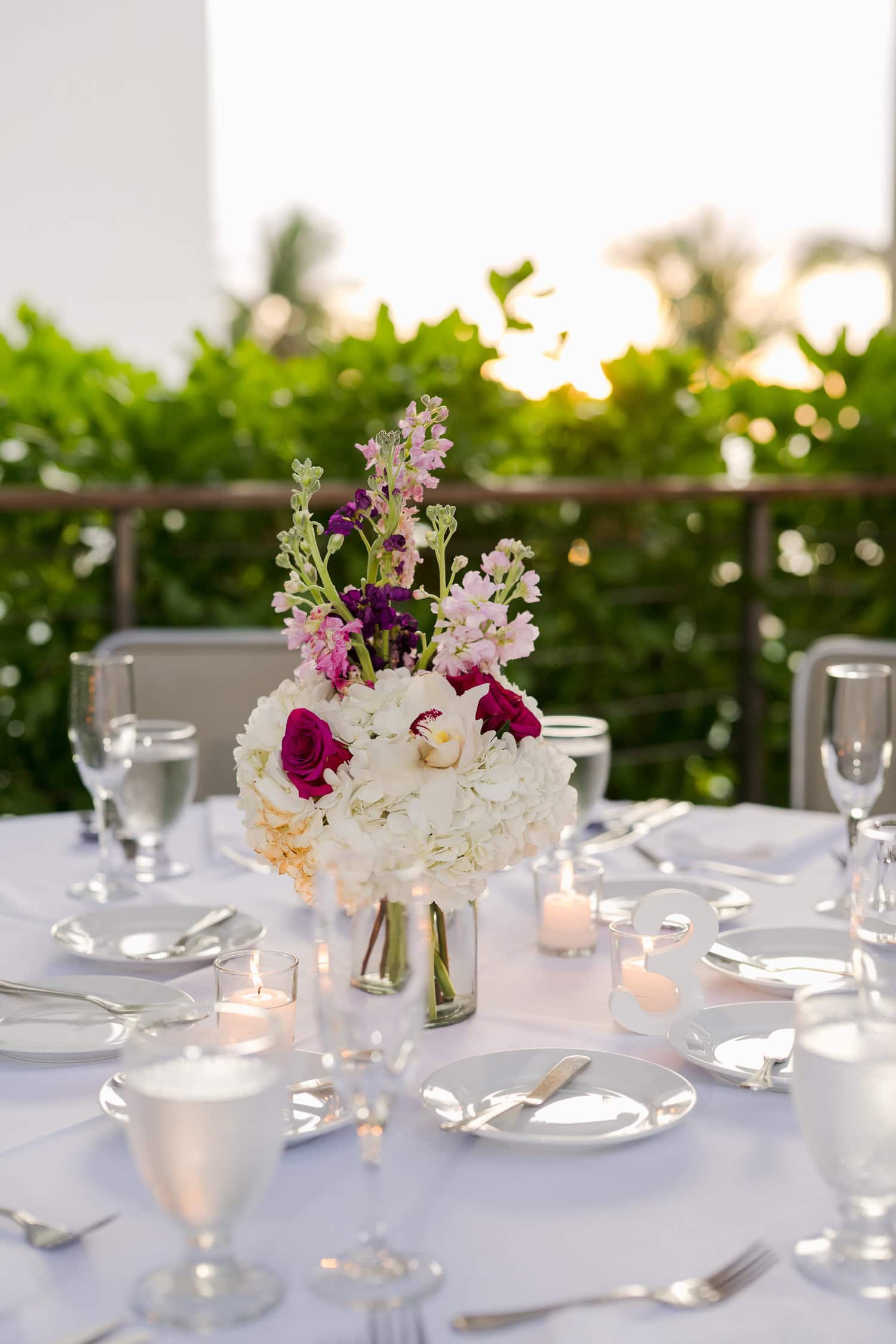 Beachfront wedding ceremony setup with a floral arch and palm trees at Courtyard Marriott Isla Verde, Puerto Rico.