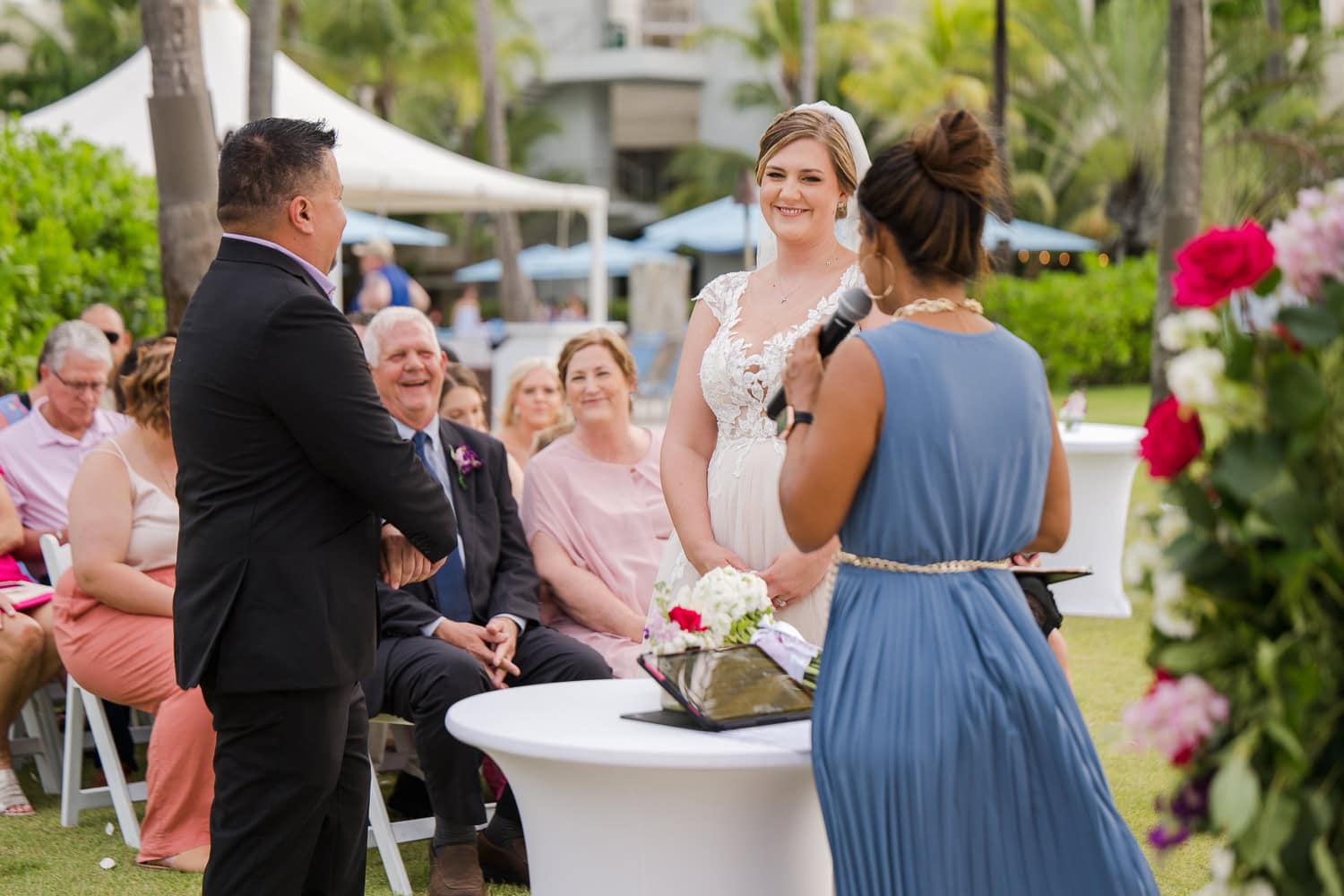 Beachfront wedding ceremony setup with a floral arch and palm trees at Courtyard Marriott Isla Verde, Puerto Rico.