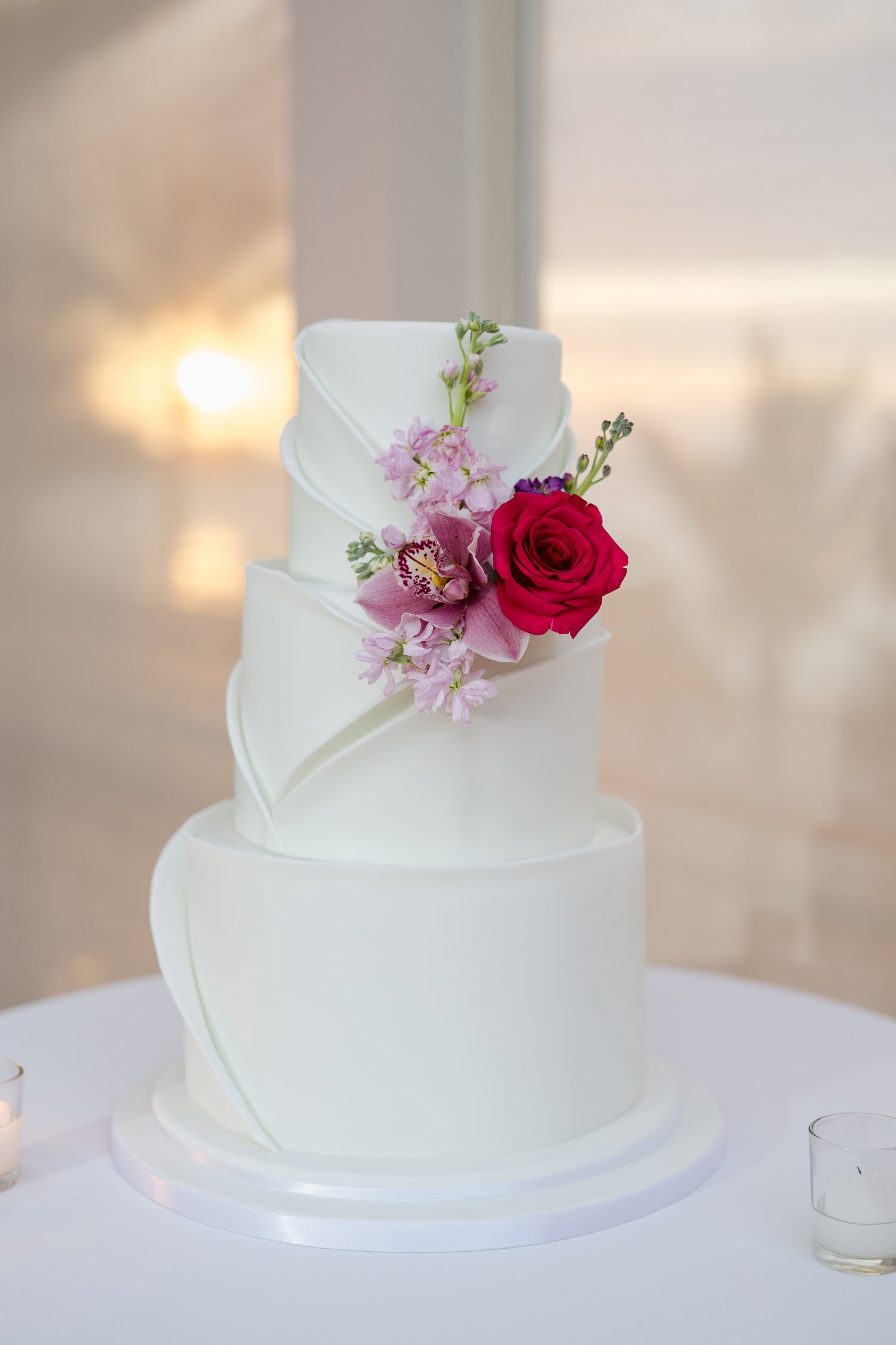 Beachfront wedding ceremony setup with a floral arch and palm trees at Courtyard Marriott Isla Verde, Puerto Rico.