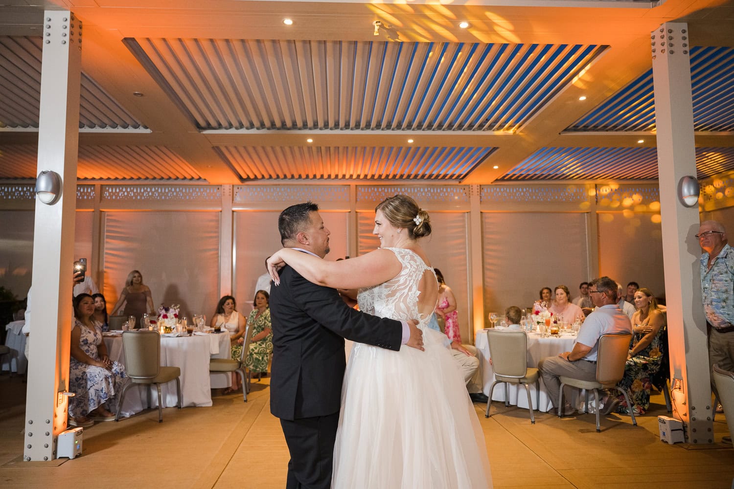 Beachfront wedding ceremony setup with a floral arch and palm trees at Courtyard Marriott Isla Verde, Puerto Rico.