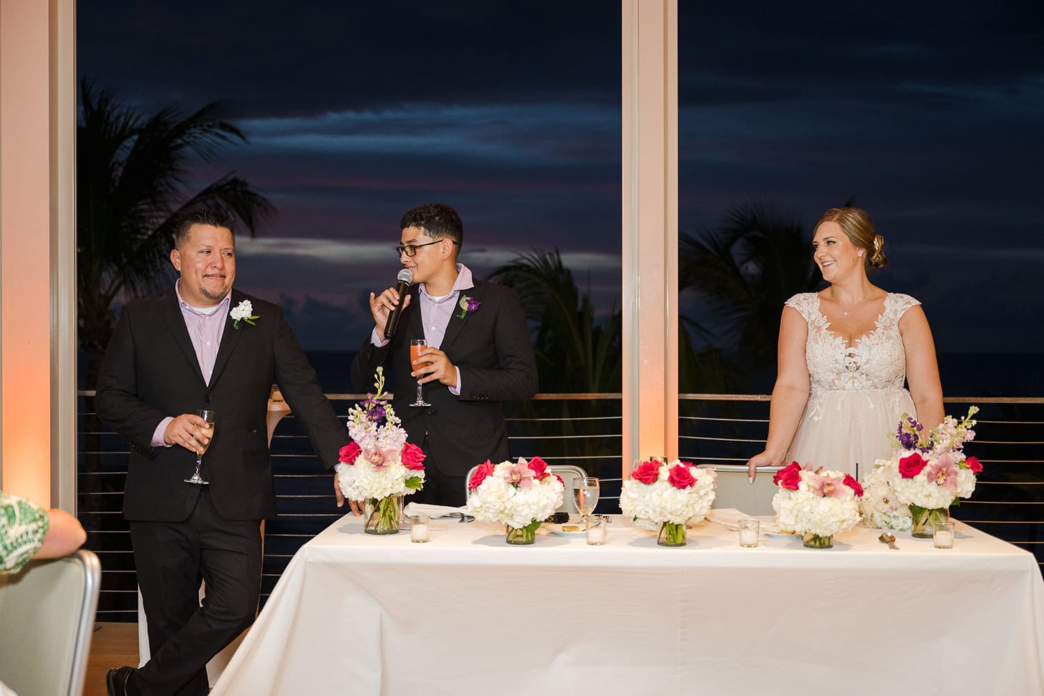 Beachfront wedding ceremony setup with a floral arch and palm trees at Courtyard Marriott Isla Verde, Puerto Rico.