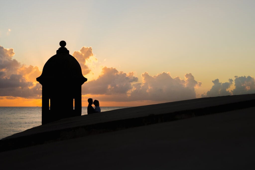 Romantic sunrise engagement photo at El Morro, San Juan.