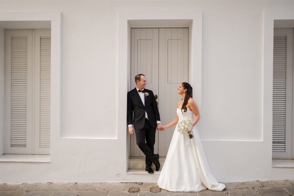 Bride and groom embracing near the city walls with views of San Juan bay