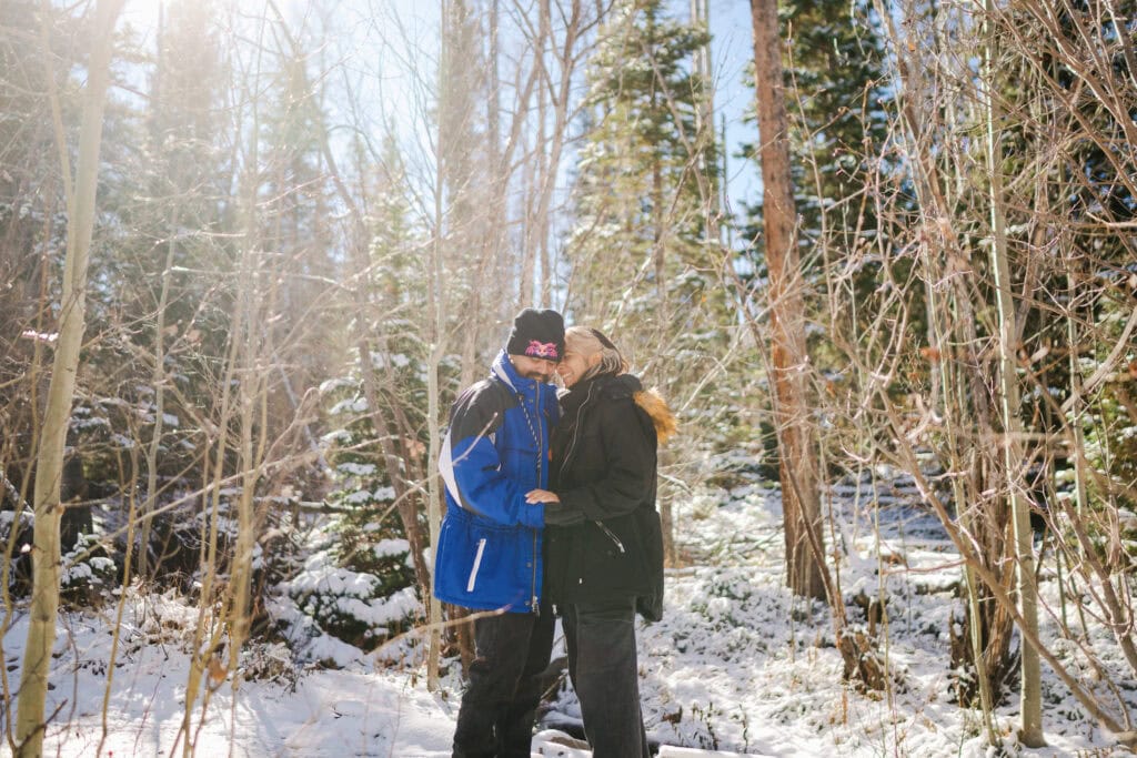 Adventure engagement proposal in snowy Colorado forest