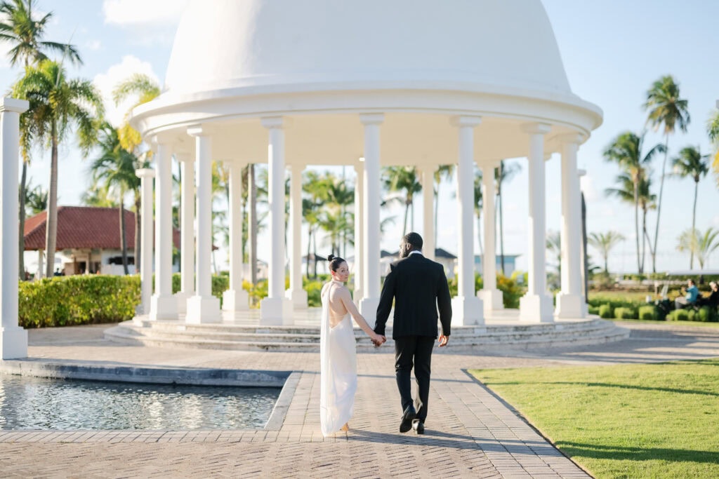 Black and white portrait of bride and groom holding hands at the Hyatt Regency Grand Reserve cupula dome