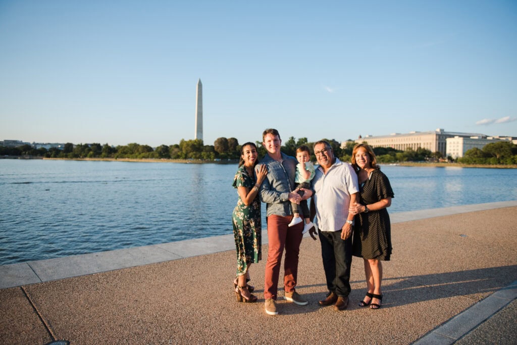 Family playing near the Tidal Basin at golden hour, Washington Monument visible in background