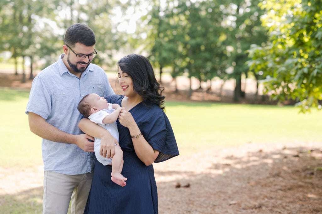 A candid family photography session in Birmingham, Alabama, capturing a sweet three month old and his parents at home and in a neighborhood park at The Preserve.
