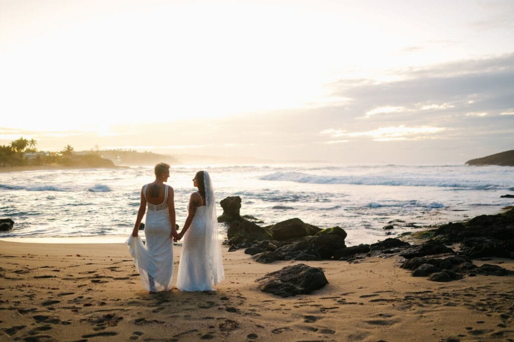 A same-sex sunset elopement on a hidden beach in Camuy, Puerto Rico, with homemade bouquets, a friend officiant, champagne, and dancing until dark.