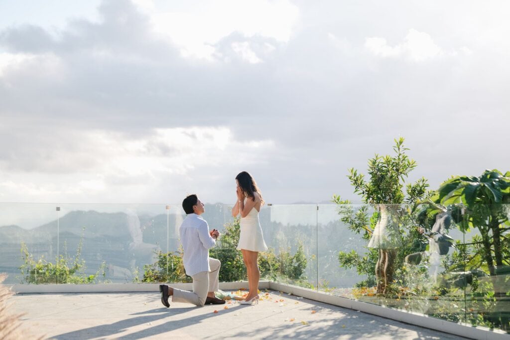 A surprise proposal at Casamerica in Cayey, Puerto Rico, with a tulip bouquet, scattered petals, and panoramic mountain views