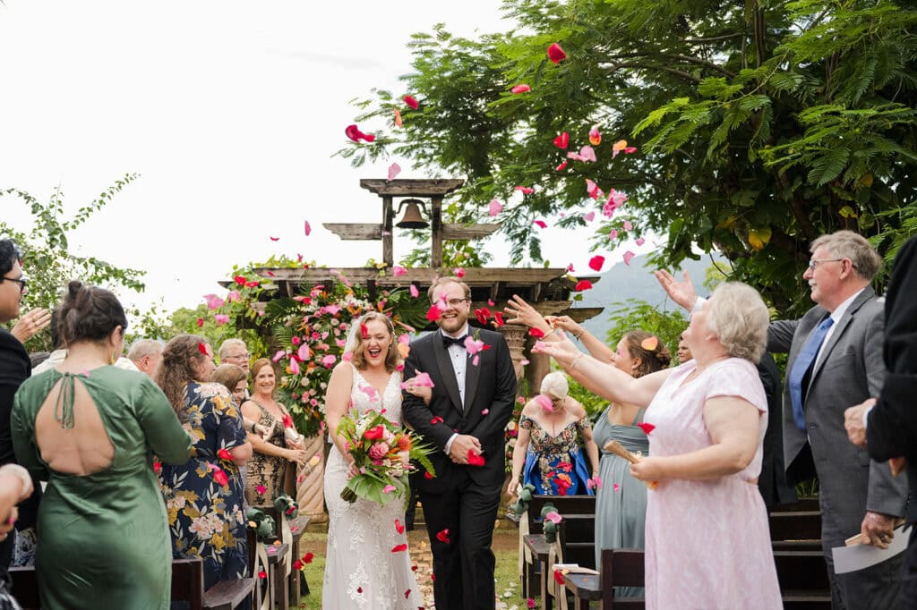 bride and groom walking back the aisle after their siesta alegre wedding ceremony with a rose petal toss
