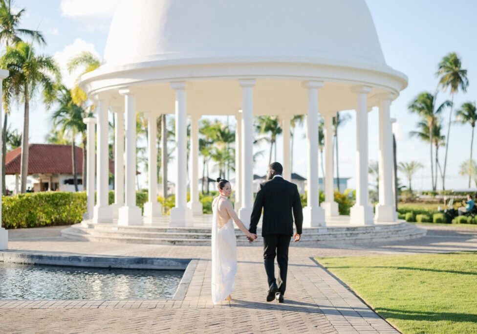 Black and white portrait of bride and groom holding hands at the Hyatt Regency Grand Reserve cupula dome