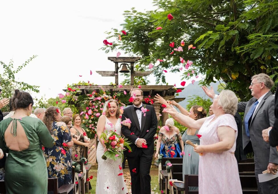 bride and groom walking back the aisle after their siesta alegre wedding ceremony with a rose petal toss