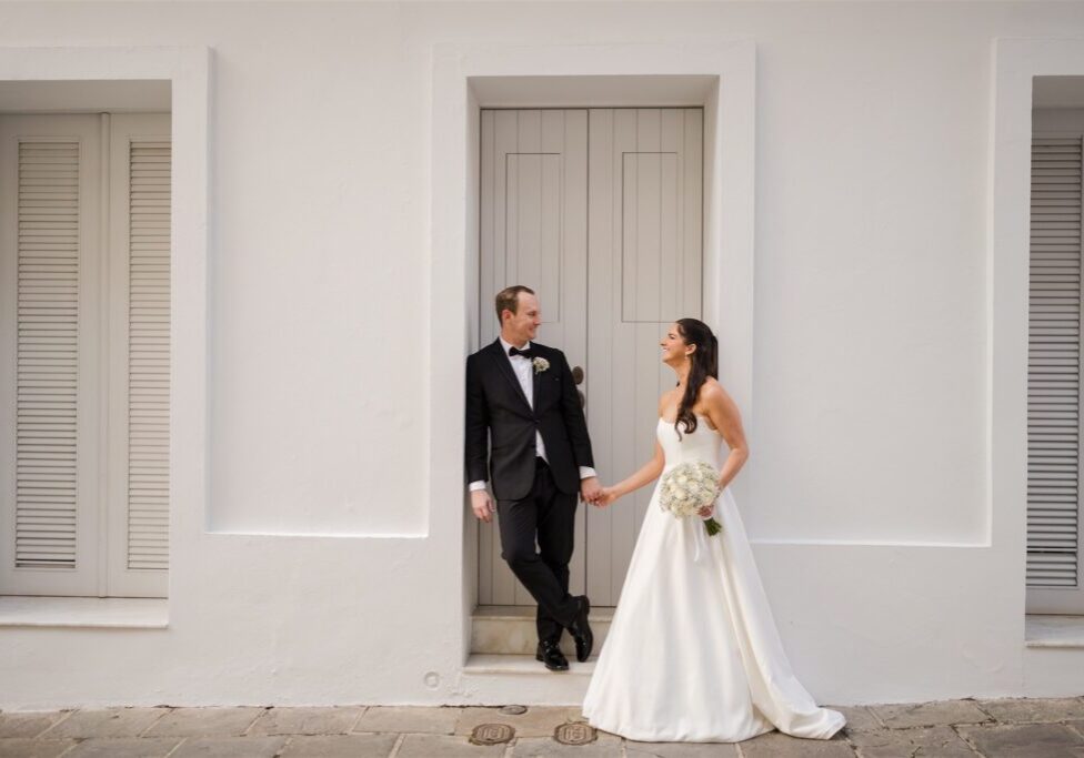 Bride and groom embracing near the city walls with views of San Juan bay
